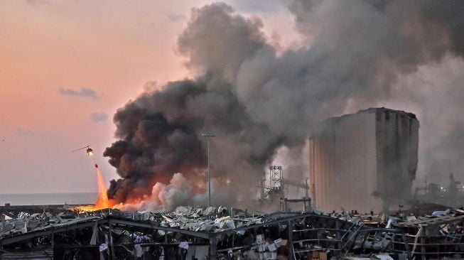 Sebuah helikopter memadamkan api di lokasi ledakan di pelabuhan kota di Beirut, Lebanon, Selasa (4/8).  [Foto/AFP]