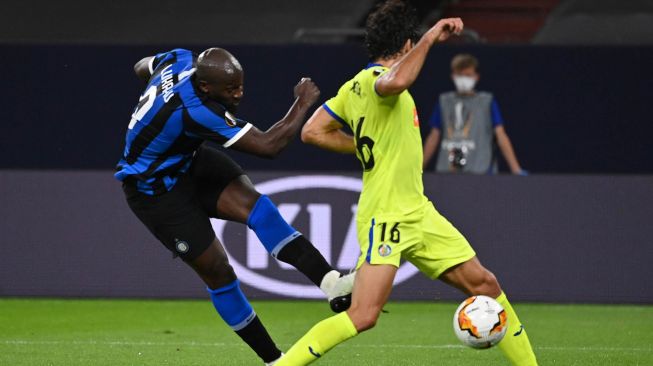 Penyerang Inter Milan Romelu Lukaku (kiri) mencetak gol pembuka melewati bek Getafe Xabier Etxeita selama pertandingan sepak bola babak 16 besar Liga Europa UEFA Inter Milan melawan Getafe di Gelsenkirchen, Jerman, Kamis (6/8) dini hari WIB. [Ina Fassbender / AFP / POOL]