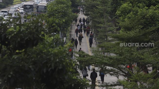 Sejumlah pekerja melintas di waktu pulang kerja di kawasan Sudirman, Jakarta, Kamis (6/8/2020). [Suara.com/Angga Budhiyanto]