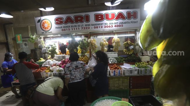 Pedagang menata dagangannya di Pasar Senen, Jakarta, Kamis (6/8/2020). [Suara.com/Angga Budhiyanto]