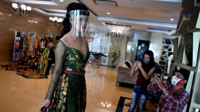 Model mengenakan pelindung wajah melakukan peragaan busana pengantin tradisional bermotif batik di Surabaya, Jawa Timur, Kamis (6/8/2020).  [FOTO/Zabur Karuru]