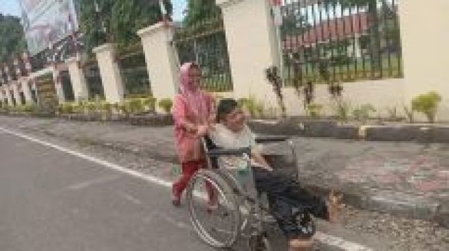 Wajah Bahagia Asral Terpancar Setelah Dapat Bantuan Kursi Roda