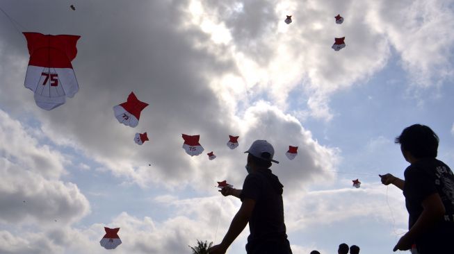 Sejumlah pemuda menerbangkan layang-layang bernuansa kemerdekaan di kawasan Sempidi, Badung, Bali, Sabtu (8/8/2020). [ANTARA FOTO/Fikri Yusuf]