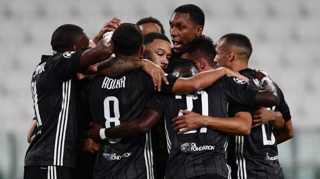 Penyerang Lyon Memphis Depay merayakan gol pertama timnya selama pertandingan sepak bola leg kedua babak 16 besar Liga Champions antara Juventus melawan Lyon di Allianz Stadium, Turin, Italia, Sabtu (8/8). dini hari WIB. [Miguel MEDINA / AFP]