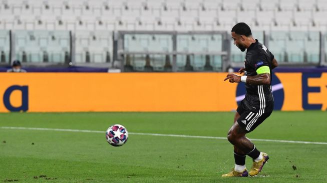Pemain depan Lyon Memphis Depay mencetak gol dari tendangan penalti selama selama pertandingan sepak bola leg kedua babak 16 besar Liga Champions antara Juventus melawan Lyon di Allianz Stadium, Turin, Italia, Sabtu (8/8). dini hari WIB. [Miguel MEDINA / AFP]