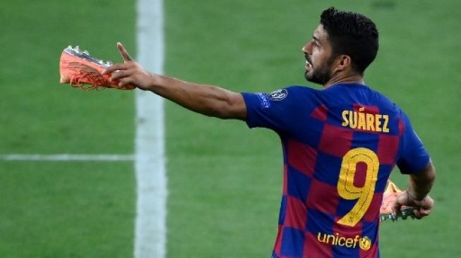 Aksi striker Barcelona Luis Suarez usai pertandingan setelah mengalahkan Napoli di leg kedua babak 16 besar Liga Champions di Camp Nou stadium. LLUIS GENE / AFP
