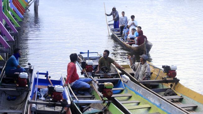 Sejumlah warga menggunakan jasa perahu saat mengunjungi permukiman suku Bajo, Torosiaje, Kabupaten Pohuwato, Gorontalo, Minggu (9/8/2020). [ANTARA FOTO/Adiwinata Solihin]