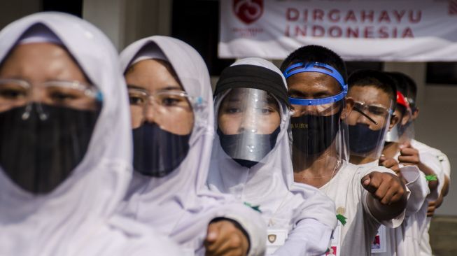 Tim Paskibraka Kota Bandung melakukan latihan menggunakan masker dan pelindung wajah di Balai Kota Bandung, Jawa Barat, Minggu (9/8/2020). [ANTARA FOTO/Novrian Arbi]