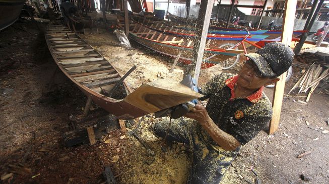 Pekerja menyelesaikan pembuatan jukung (perahu) tradisional di Desa Pulau Sewangi, Kabupaten Barito Kuala, Kalimantan Selatan, Senin (10/8/2020). [ANTARA FOTO/Bayu Pratama S]