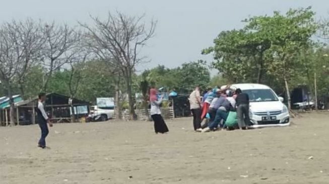 Suzuki Ertiga terjebak di pantai. (Facebook/About Tangerang)