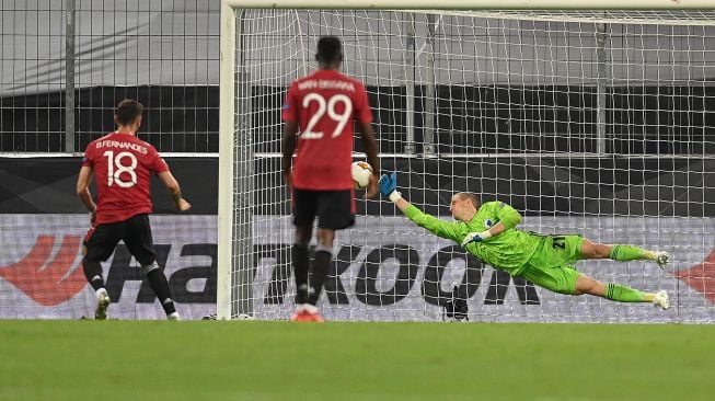 Gelandang Manchester United Bruno Fernandes mencetak gol melalui penalti selama pertandingan sepak bola perempat final Liga Europa antara Manchester United melawan Copenhagen di RheinEnergieStadion stadium, Selasa (11/8/2020) dini hari WIB. [RATTAY WOLFGANG / POOL / AFP]
