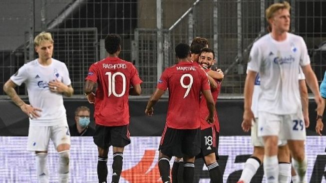 Para pemain Manchester United merayakan gol Bruno Fernandes ke gawang Copenhagen dari titik penalti di laga perempat final Liga Europa di RheinEnergieStadion stadium. Sascha Steinbach / POOL / AFP