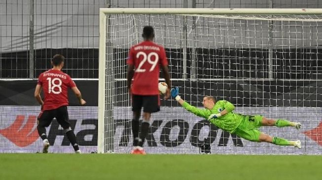 Gelandang Manchester United Bruno Fernandes (kiri) mencetak gol dari titik penalti ke gawang Copenhagen di laga perempat final Liga Europa di RheinEnergieStadion stadium. Sascha Steinbach / POOL / AFP