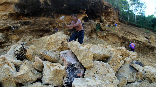 Sejumlah pekerja memecahkan batu secara tradisional di Desa Bambu, Mamuju, Sulawesi Barat, Rabu (12/8/2020). [ANTARA FOTO/ Akbar Tado]