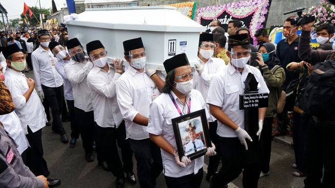 Petugas mengusung peti jenazah anggota KPU Yakuhimo, Papua almarhum Hendry Jovinski saat proses pemakaman di Rewulu Wetan, Sidokarto, Godean, Sleman, Yogyakarta, Kamis (13/8/2020).  [ANTARA FOTO/Andreas Fitri Atmoko]