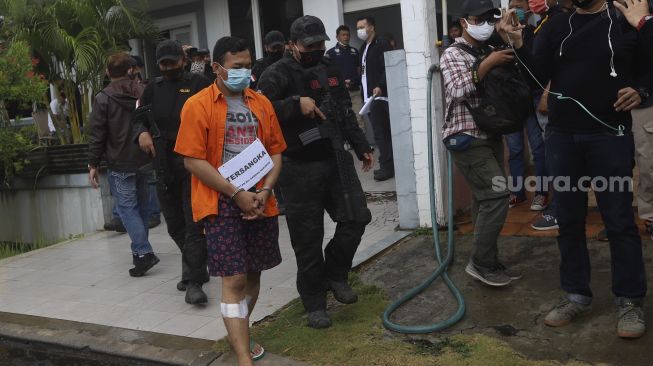 Tersangka Alfiyan memperagakan reka ulang pembunuhan WN Taiwan, Hsu Ming Hu di Tempat Kejadian Perkara (TKP) di Cikarang, Kabupaten Bekasi, Jawa Barat, Kamis (13/8/2020). [Suara.com/Angga Budhiyanto]