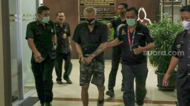 Aktor Tio Pakusadewo berjalan keluar usai menjalani pemeriksaan di Kejaksaan Negeri Jakarta Selatan, Kamis (13/8). [Suara.com/Alfian Winanto]