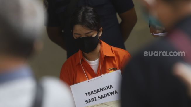 Tersangka Sari Sadewa memperagakan reka ulang perencanaan pembunuhan WN Taiwan di Direktorat Reserse Kriminal Umum Subdit Resmob, Polda Metro Jaya, Jakarta, Kamis (13/8/2020). [Suara.com/Angga Budhiyanto]