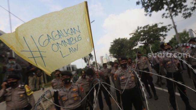 Aparat Kepolisian berjaga saat massa mahasiswa dari berbagai universitas melakukan aksi unjuk rasa di sekitar Gedung DPR/MPR RI, Jumat (14/8/2020). [Suara.com/Angga Budhiyanto]