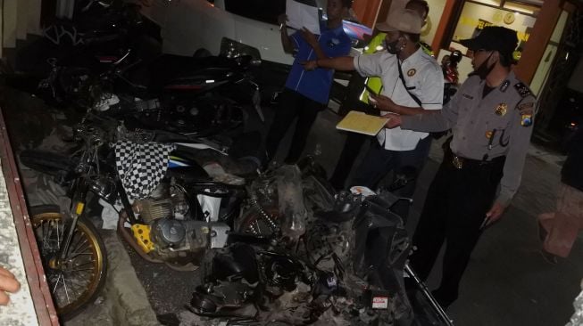 Polisi mengidentifikasi sepeda motor yang terlibat kecelakaan beruntun di jalan nasional Jember-Banyuwangi Desa Sempolan, Silo, Jember, Jawa Timur, Kamis (13/8/2020).  [ANTARA FOTO/Seno]