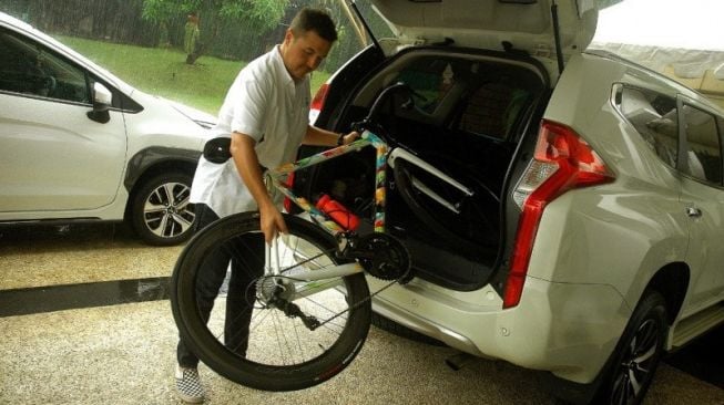 Pereli Rifat Sungkar memperagakan cara memasukkan sepeda dari bagasi di Mitsubishi Xpander [Mitsubishi Indonesia].