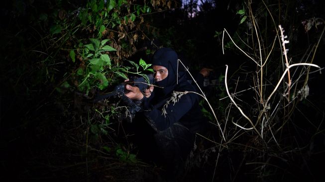 Pasukan Katak TNI AL mengintai dari semak belukar pada Latihan Operasi Dukungan Pasukan Khusus Gabungan TNI AL di kawasan Pantai Tengket, Bangkalan, Jawa Timur, Jumat (14/8/2020).  [ANTARA FOTO/Zabur Karuru]