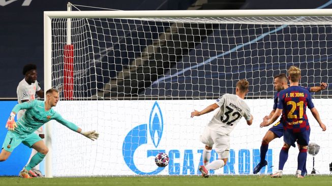 Gelandang Bayern Muenchen Joshua Kimmich (tengah) mencetak gol kelima timnya selama pertandingan sepak bola perempat final Liga Champions antara Barcelona melawan Bayern Muenchen di Estadio da Luz, Lisbon, Portugal, Sabtu (15/8/2020) dini hari WIB. [Foto/AFP]
