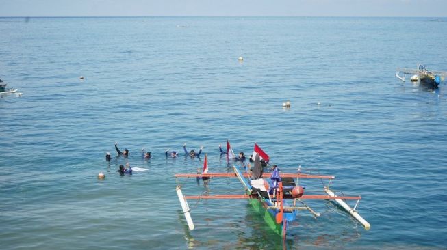 HUT RI, 20 Penyelam Bentangkan Bendera Merah Putih di Dasar Laut Botubarani