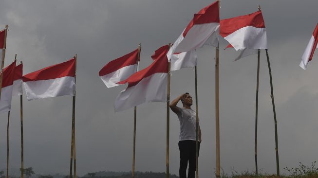 Seorang pengunjung memberi hormat ke bendera Merah Putih yang dipasang di Poetoek Suko, Trawas, Mojokerto, Jawa Timur, Minggu (16/8/2020). [ANTARA FOTO/Zabur Karuru]