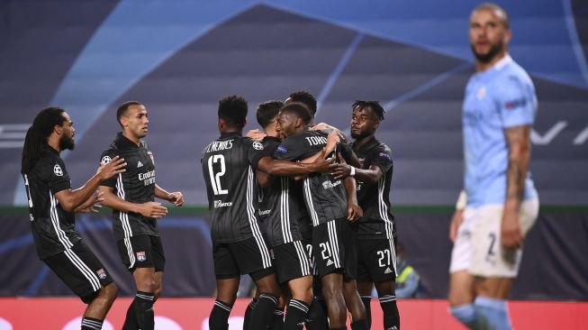 Penyerang Lyon Moussa Dembele merayakan bersama rekan satu timnya setelah mencetak gol kedua Lyon selama pertandingan sepak bola perempat final Liga Champions UEFA antara Manchester City dan Lyon di stadion Jose Alvalade, Lisbon pada (15/8/2020). [FRANCK FIFE / AFP / POOL]