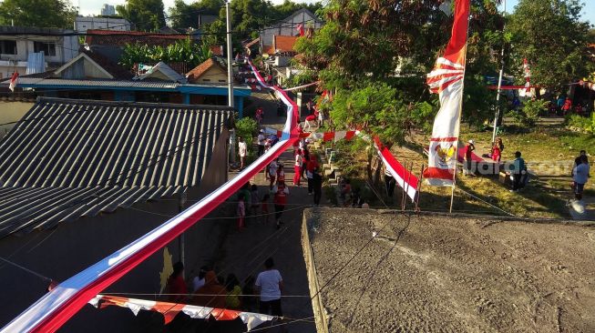 Bendera Merah-Putih sepanjang 1.300 Meter ini dibentangkan sepanjang kampung. (Suara.com/Dimas)