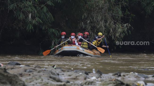 Petugas upacara menaiki perahu karet saat melaksanakan upacara bendera di Sungai Ciliwung, GDC, Depok, Jawa Barat, Senin (17/8/2020). [Suara.com/Angga Budhiyanto]