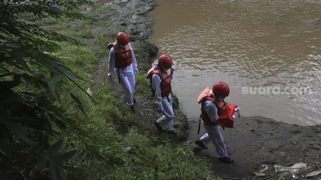 Petugas upacara membawa bendera Merah Putih sebelum melaksanakan upacara bendera di Sungai Ciliwung, GDC, Depok, Jawa Barat, Senin (17/8/2020). [Suara.com/Angga Budhiyanto]