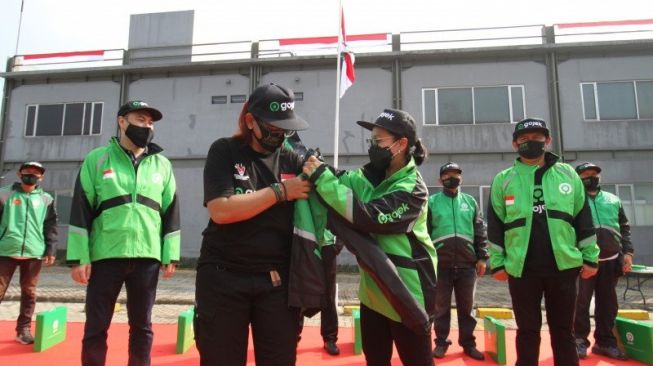 Gojek mengadakan upacara di kantor operasional Kemang Timur, Jakarta (17/8/2020). Chief Corporate Affairs Gojek, Nila Marita & Chief of Operations Officer Gojek, Hans Patuwo (kiri) menyematkan secara simbolis jaket mitra driver Gojek dari Thailand dan Vietnam kepada salah satu perwakilan mitra driver Indonesia, sekaligus menandakan peluncuran resmi aplikasi GoPartner [Gojek Indonesia via ANTARA/HO].