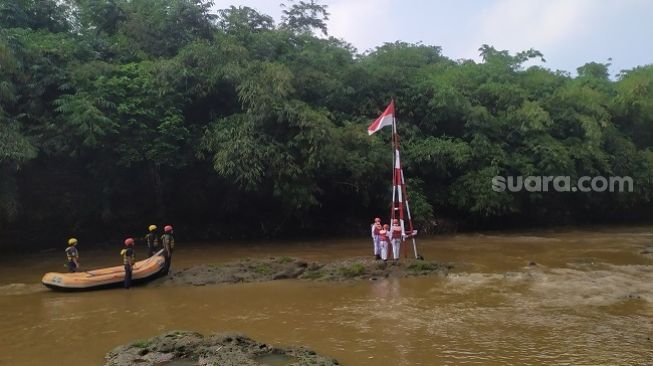 Warga Depok Gelar Upacara Kemerdekaan di Tengah Derasnya Sungai Ciliwung