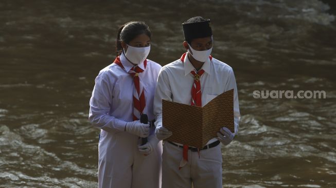 Petugas upacara bersiap melaksanakan upacara bendera di Sungai Ciliwung, GDC, Depok, Jawa Barat, Senin (17/8/2020). [Suara.com/Angga Budhiyanto]