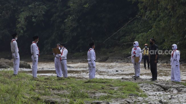 Petugas upacara saat melaksanakan upacara bendera di Sungai Ciliwung, GDC, Depok, Jawa Barat, Senin (17/8/2020). [Suara.com/Angga Budhiyanto]