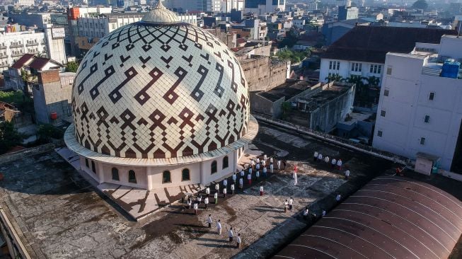 Foto udara sejumlah pengurus Dewan Kemakmuran Masjid (DKM) mengikuti upacara peringatan kemerdekaan Republik Indonesia di atap Masjid Raya Bandung, Jawa Barat, Senin (17/8/2020).  [ANTARA FOTO/Raisan Al Farisi]