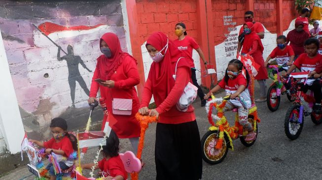 Peserta mengenakan masker dan pelindung wajah saat mengikuti pawai kemerdekaan menuju Jalan Keadilan di Rangkapan Jaya Baru, Depok, Jawa Barat, Senin (17/8/2020).  [ANTARA FOTO/Wahyu Putro]