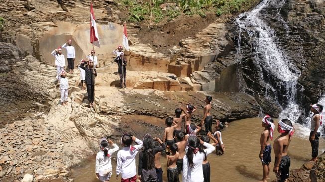 Sejumlah warga mengikuti upacara bendera di Curug Tarung kawasan lereng gunung Prahu Dusun Gunung Wuluh, Canggal, Candiroto, Temanggung, Jawa Tengah, Selasa (18/8/2020). [ANTARA FOTO/Anis Efizudin]