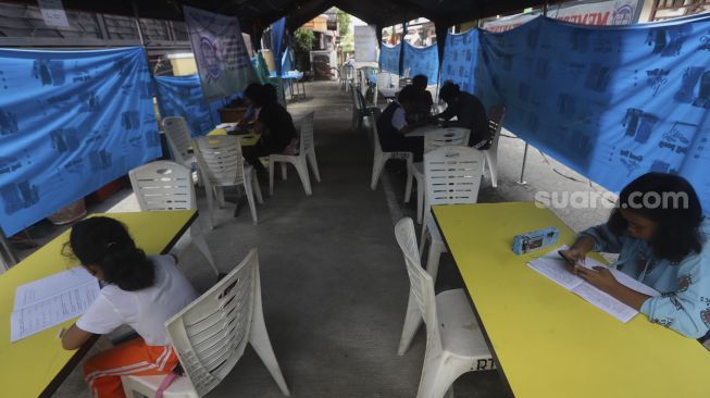 Sejumlah siswa belajar secara online di tenda wifi gratis di taman warga RT 013, Pondok Kelapa, Jakarta Timur, Selasa (18/8/2020). [Suara.com/Angga Budhiyanto]