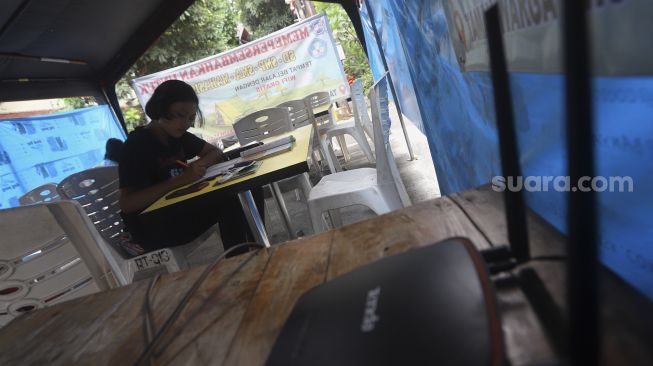 Siswa belajar secara online di tenda wifi gratis di taman warga RT 013, Pondok Kelapa, Jakarta Timur, Selasa (18/8/2020). [Suara.com/Angga Budhiyanto]