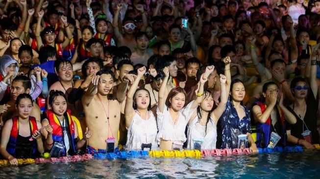 Warga Wuhan menggelar pesta kolam renang besar-besaran yang bisa dikatakan sebagai perayaan dari penghapusan lockdown beberapa bulan lalu. [AFP]