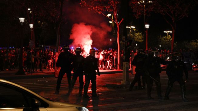 
Suporter Paris Saint-Germain (PSG) merayakan kemenangan 3-0 tim mereka atas RB Leipzig yang membuat PSG lolos ke final Liga Champions di Champs-Elysees Avenue dekat Arc de Triomphe, Paris, Perancis, Rabu (19/8) dini hari WIB.  [GEOFFROY VAN DER HASSELT / AFP]