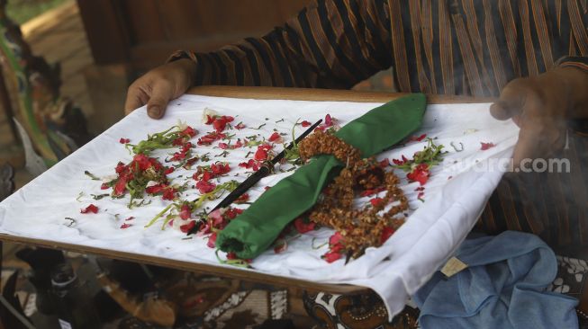 Nasip Hadi Prayitno (51) menerima pusaka berupa mata tombak saat melakukan ritual jamasan di Museum Pusaka Taman Mini Indonesia Indah (TMII), Jakarta, Kamis (20/8/2020). [Suara.com/Angga Budhiyanto]