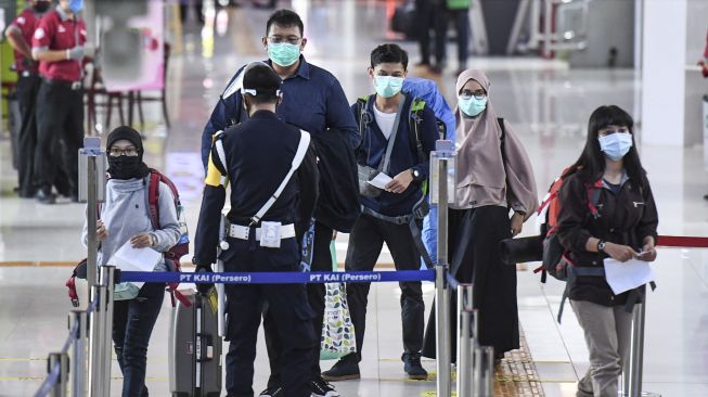 Petugas memeriksa tiket penumpang yang akan menaiki Kereta Api Turangga tujuan Surabaya Gubeng di Stasiun Gambir, Jakarta, Kamis (20/8/2020).  [ANTARA FOTO/Hafidz Mubarak]