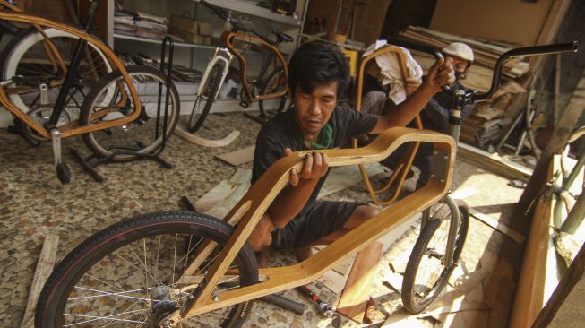 Pekerja menyelesaikan pembuatan sepeda kayu di Tapos, Depok, Jawa Barat, Kamis (20/8/2020). [ANTARA FOTO/Asprilla Dwi Adha]