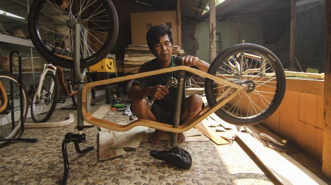 Pekerja menyelesaikan pembuatan sepeda kayu di Tapos, Depok, Jawa Barat, Kamis (20/8/2020). [ANTARA FOTO/Asprilla Dwi Adha]