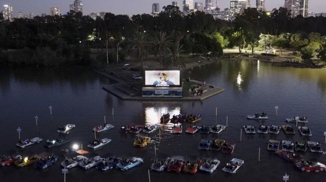 Foto udara menunjukkan sejumlah warga Israel menonton film "Paddington" sambil duduk di perahu pedal di bioskop terapung Sail-in di Taman Hayarkon Tel Aviv, Israel, (20/8/2020). [JACK GUEZ / AFP]