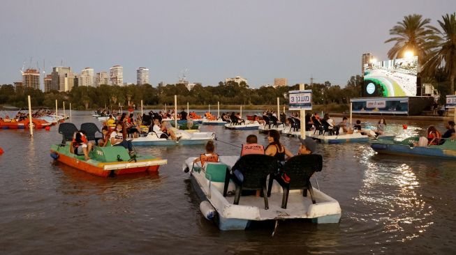 Sejumlah warga Israel menonton film "Paddington" sambil duduk di perahu pedal di bioskop terapung Sail-in di Taman Hayarkon Tel Aviv, Israel, (20/8/2020). [JACK GUEZ / AFP]